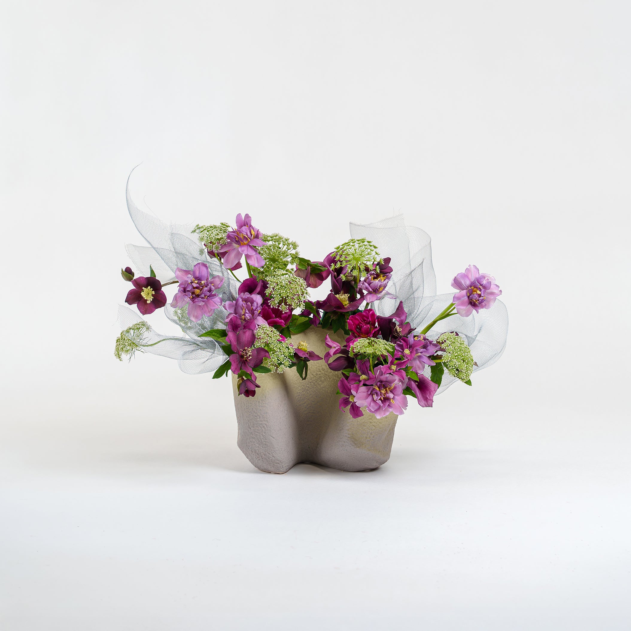 Ceramic vase with a bouquet of flowers on a white background