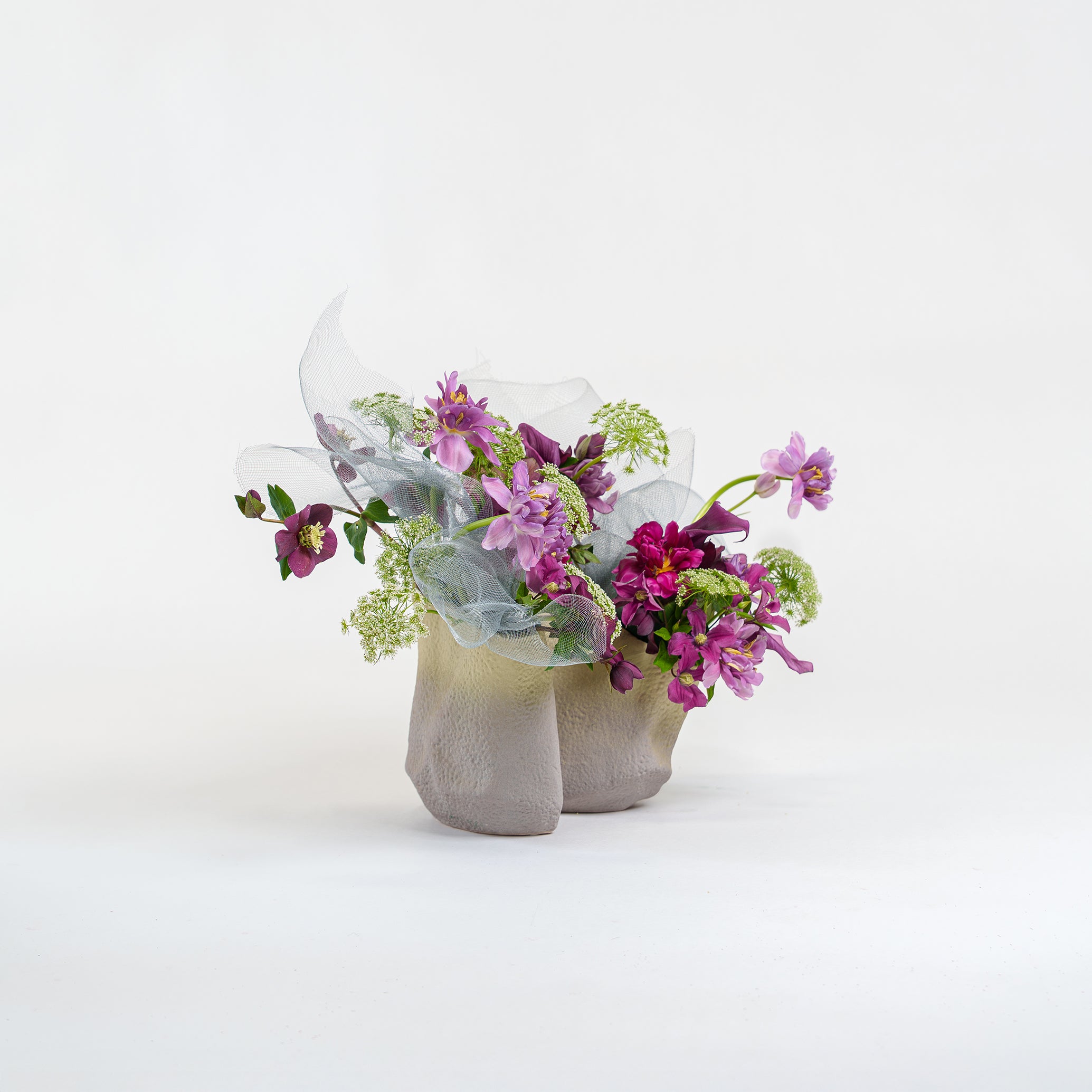 Bouquet of flowers in a concrete vase on a white background
