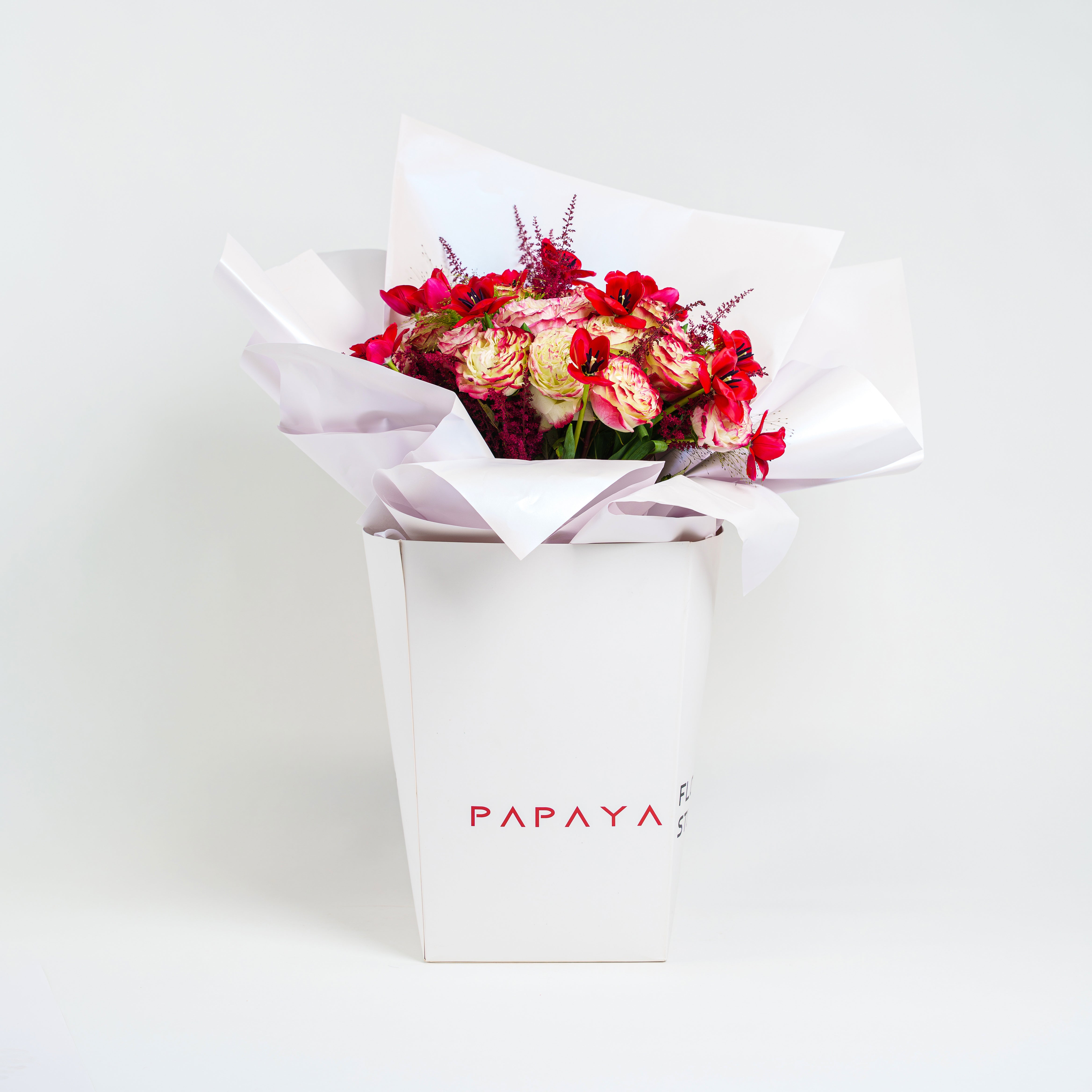 Features a stunning mix of imported bi-color garden roses and striking red anemones for valelntines day dubai