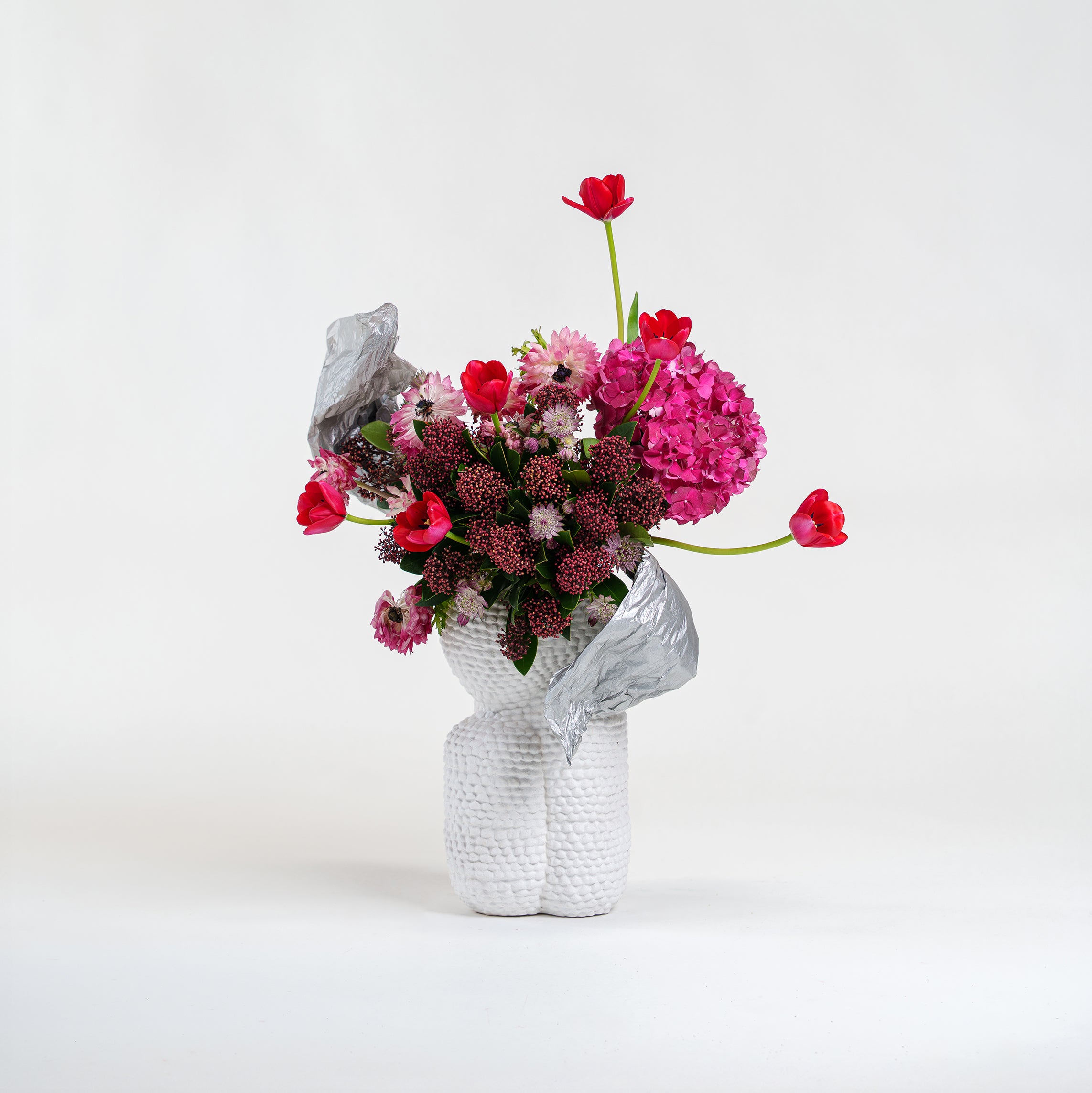 Bouquet of flowers in a unique vase on a white background