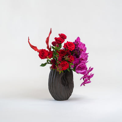 Vase with red and pink flowers on a white background