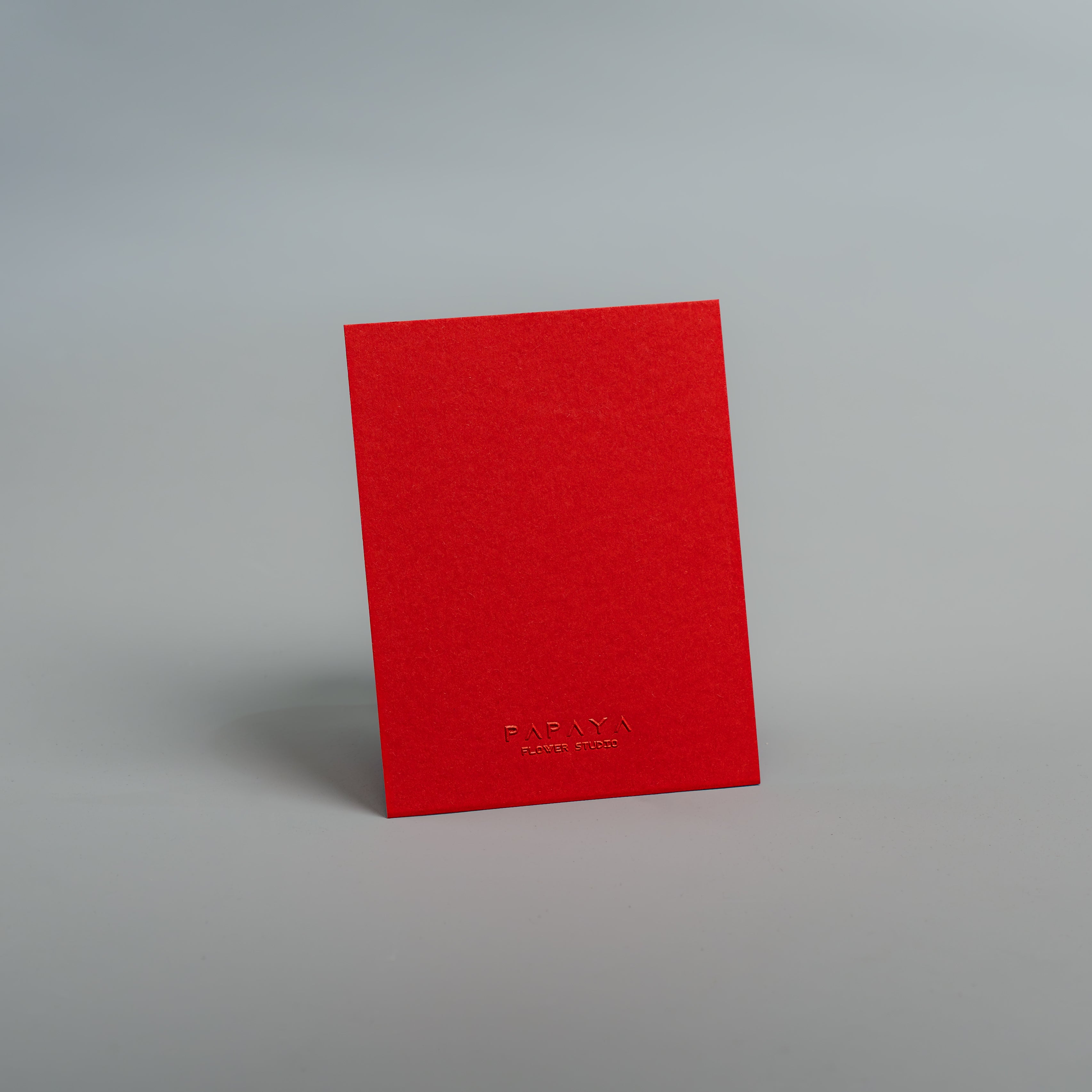 Red textured card with a brand name on a gray background