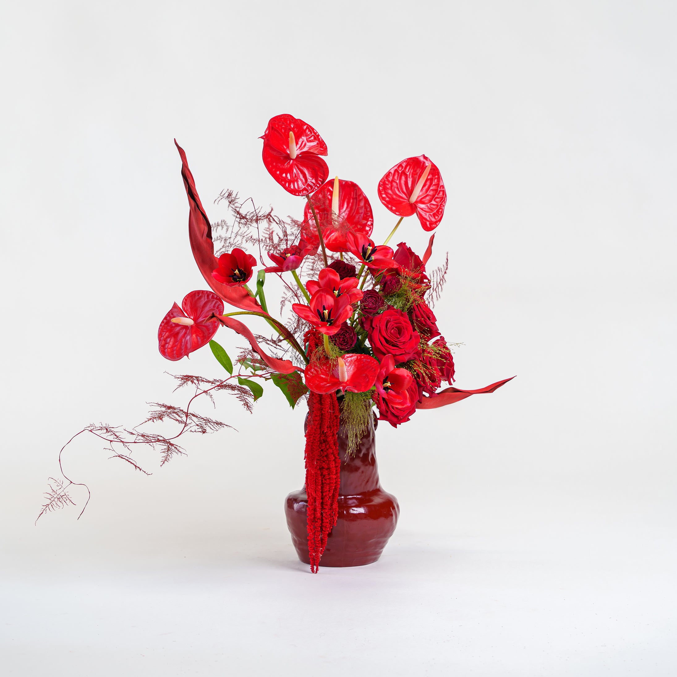 Order Rouge a luxury monochromatic red flower arrangement in a glossy burgundy vase. The ultimate statement gift. Delivery in Dubai.