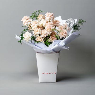 Modern bouquet of nude and champagne sand-colored reflexed roses with silver anthurium leaf in white branded carrier box delivery Dubai