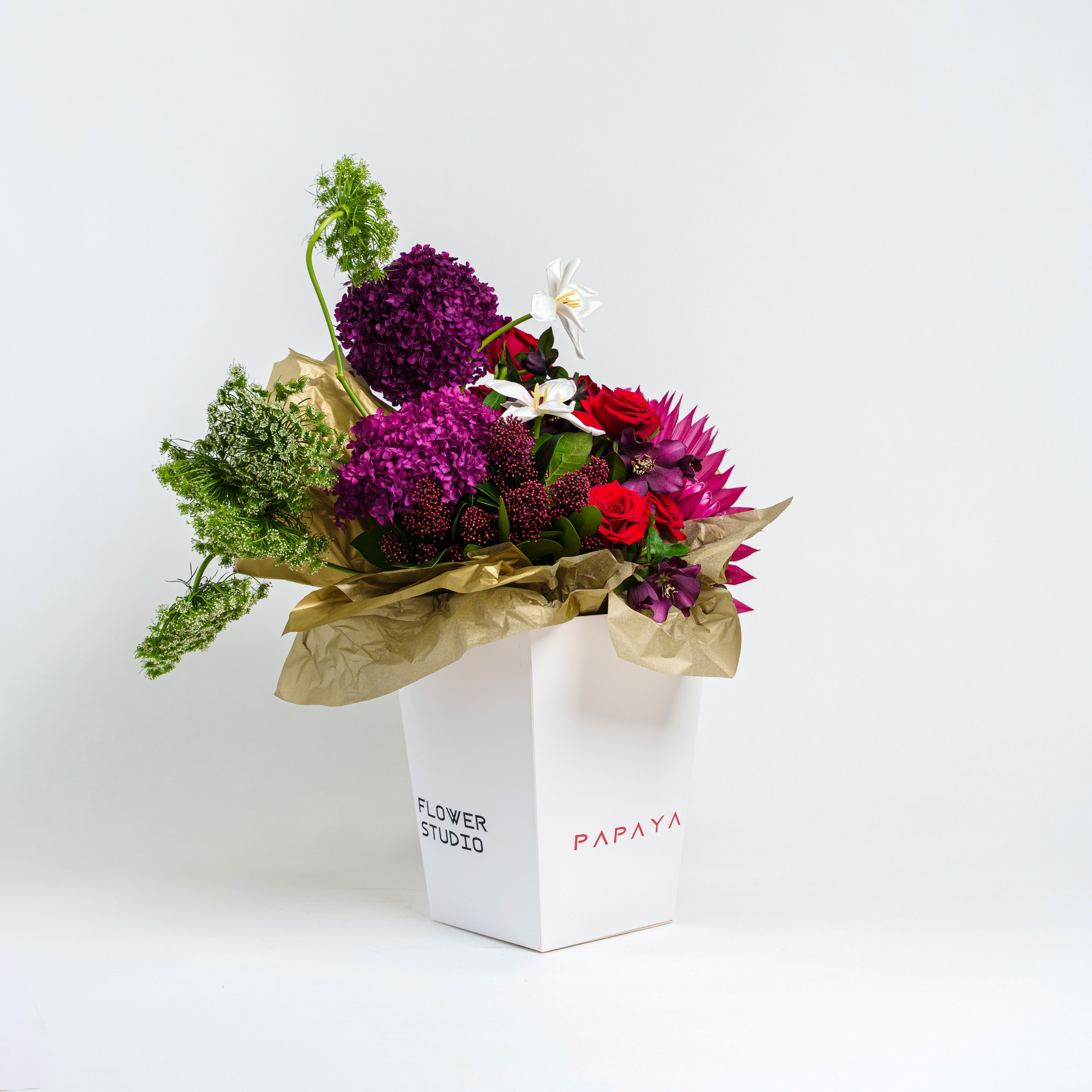 Bouquet of flowers in a white box with 'Flower Studio' and 'Papaya' branding on a light gray background