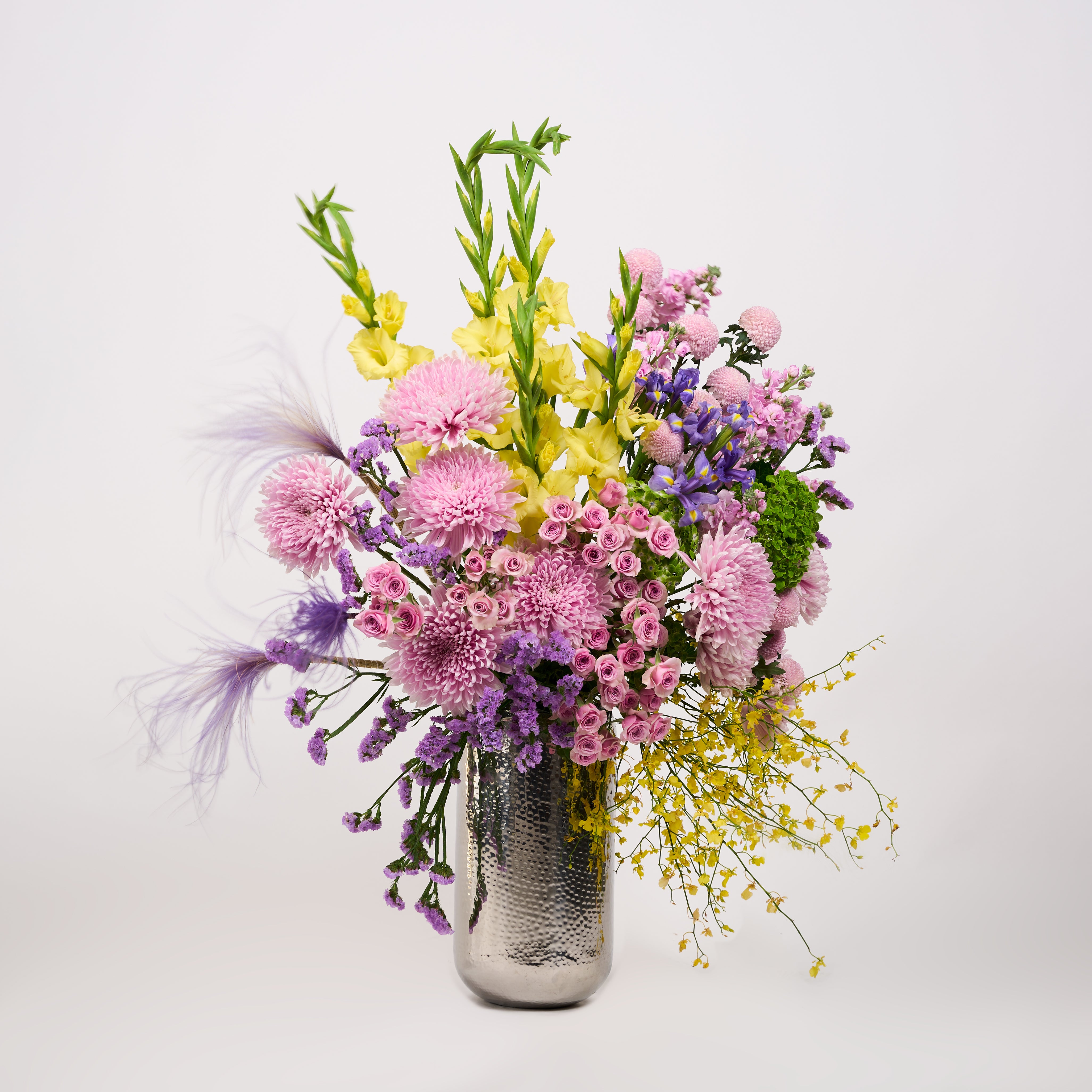 Mixed pink, purple and yellow flowers in Papaya Flower Studio’s Aria vase arrangement.