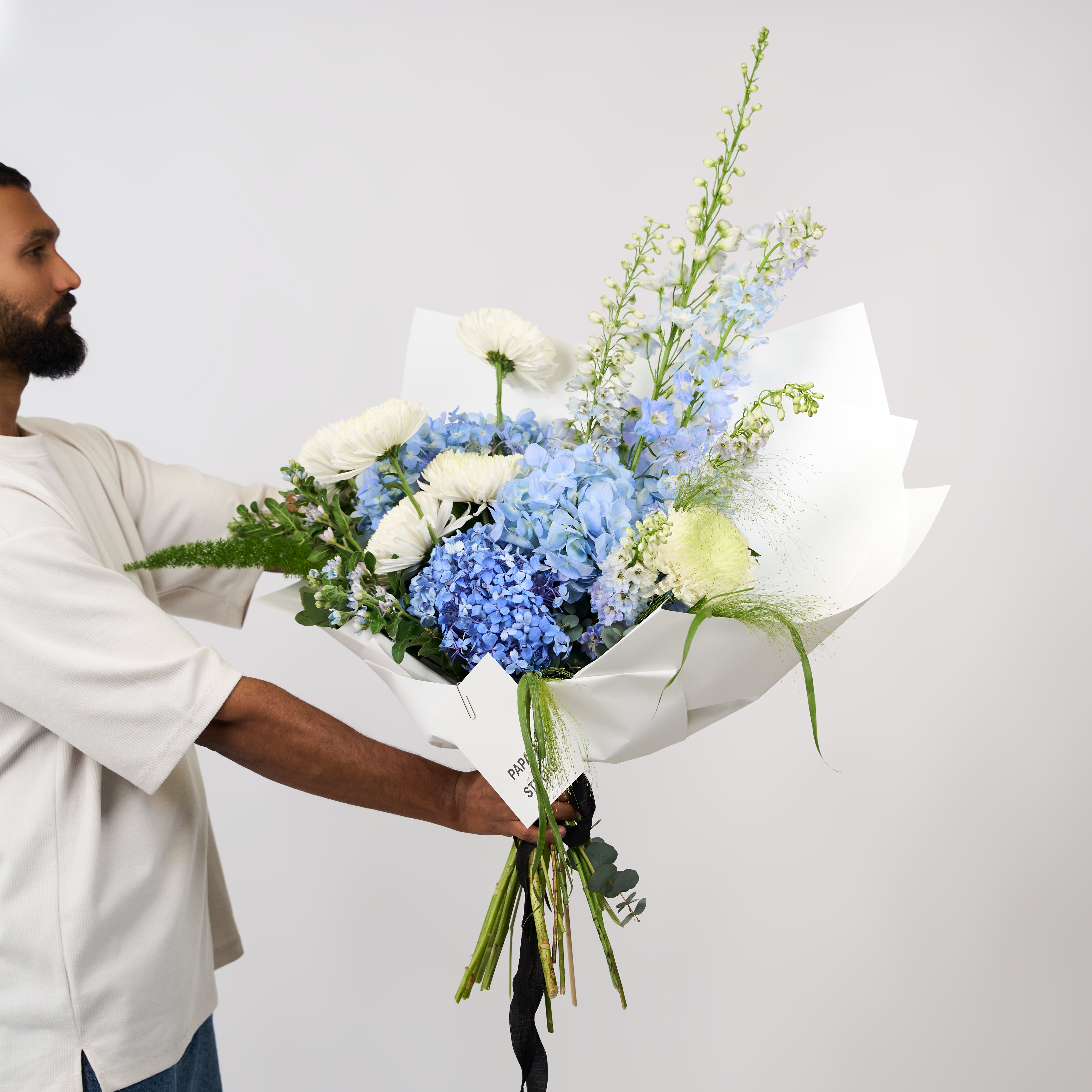 Mixed blue and white flowers with green foliage in Papaya Flower Studio’s Blue Haven bouquet.