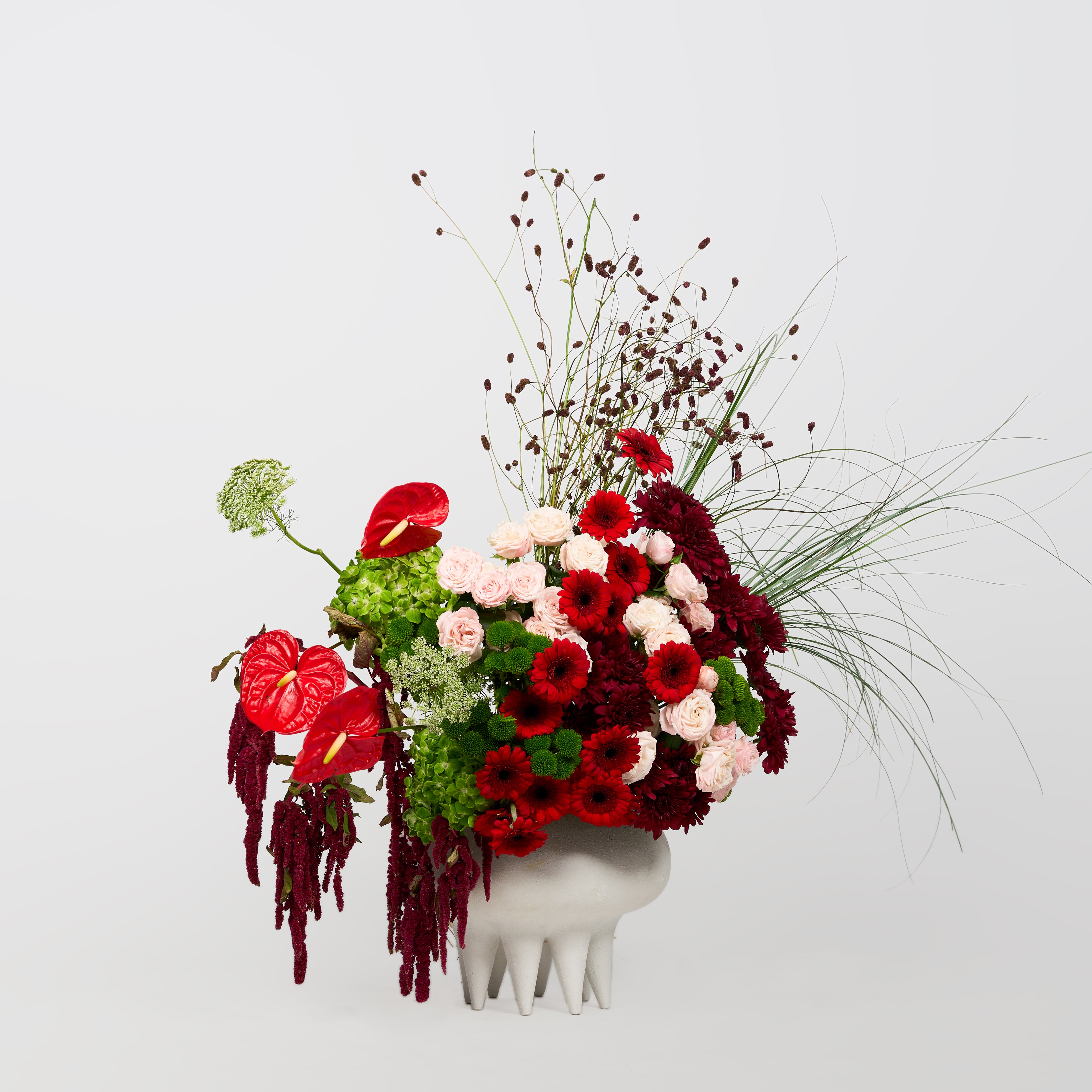 Red, burgundy and blush flowers arranged in Papaya Flower Studio’s Rosalia sculptural vase design.