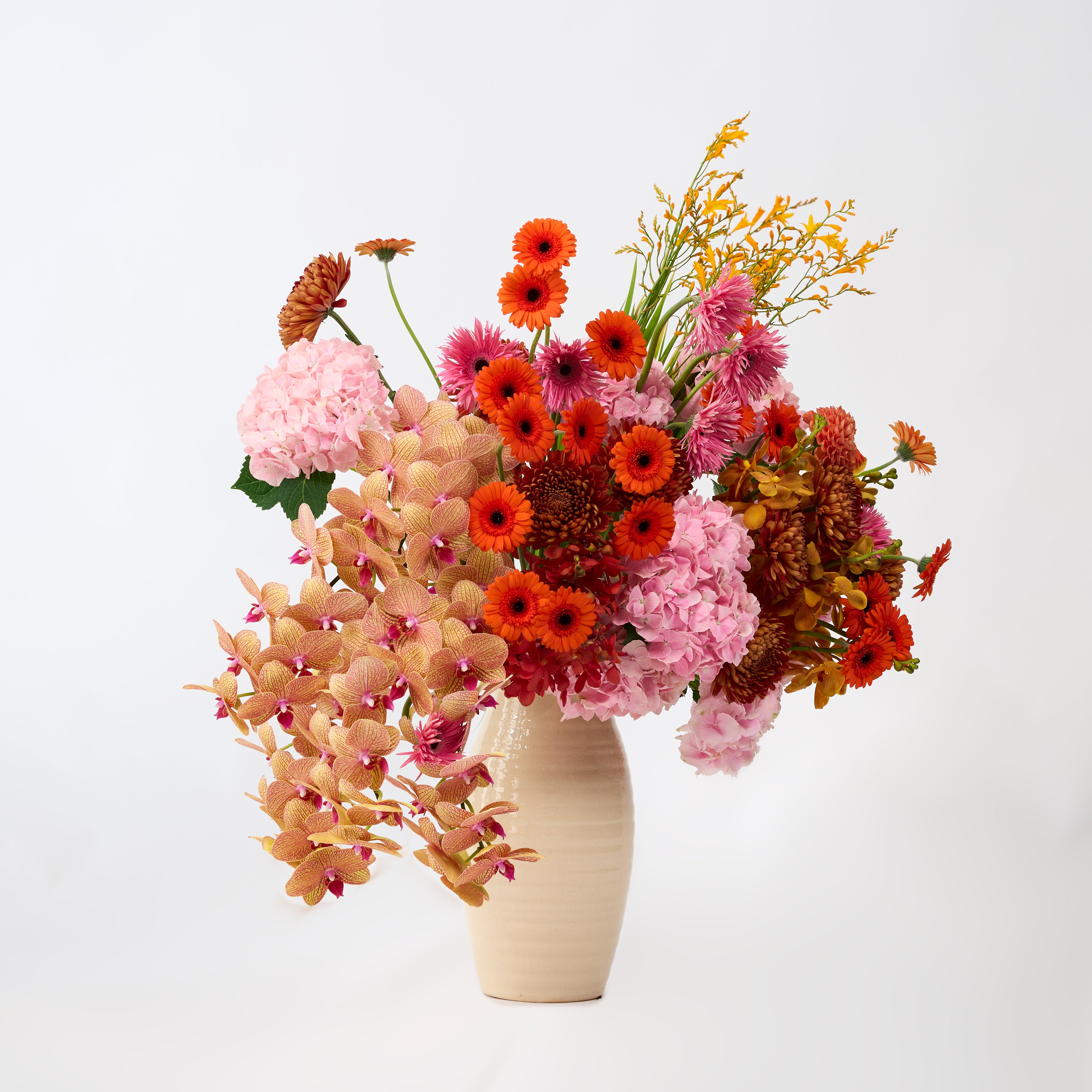 Solara vase arrangement featuring pink, orange, copper and golden flowers.