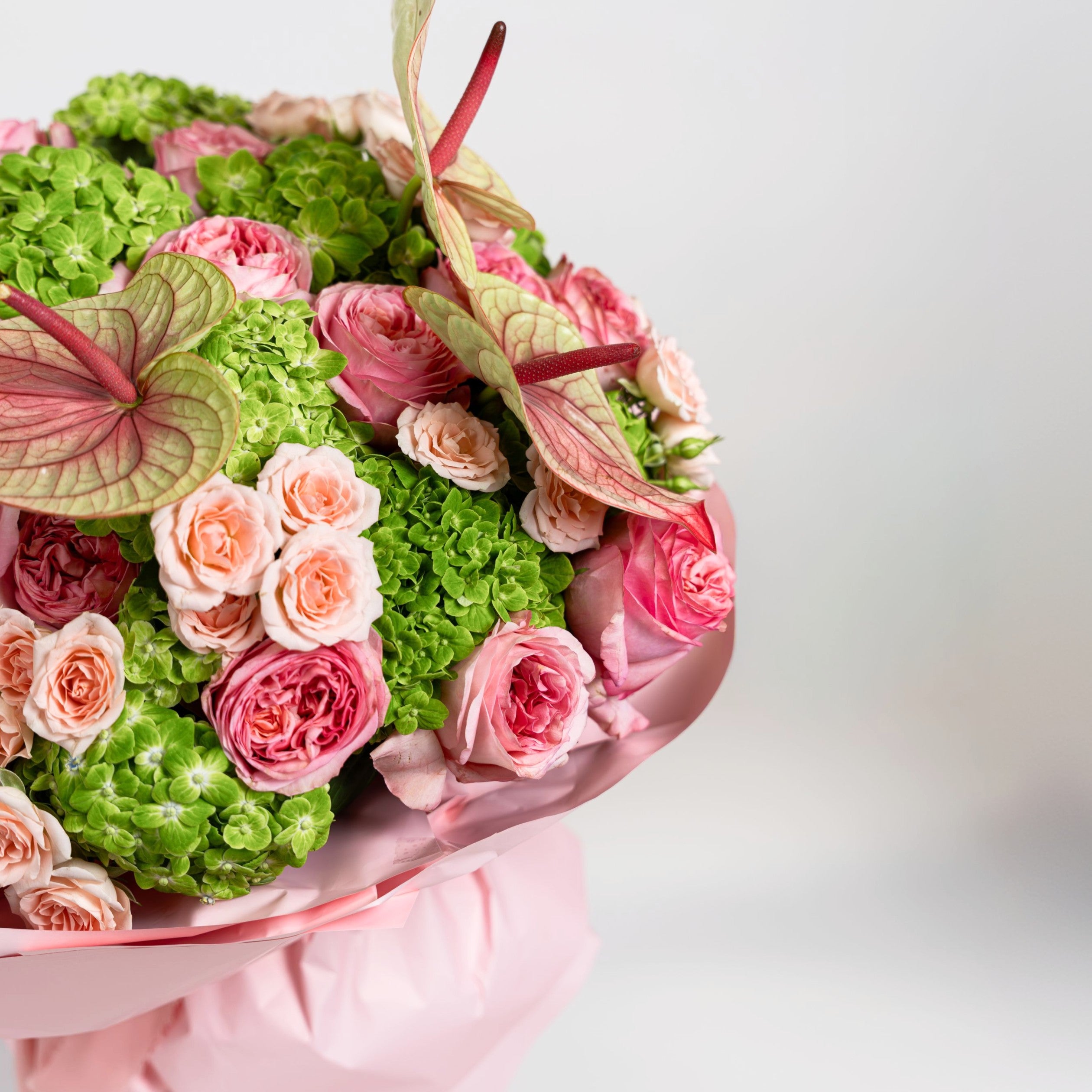 Side detail of pink roses, green hydrangeas and anthuriums in a luxury Papaya flower box