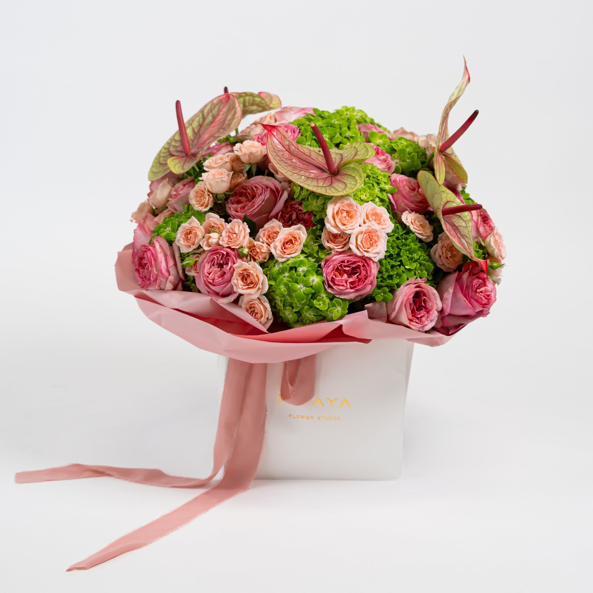 The Eden Affair pink anthurium bouquet with garden roses and green hydrangeas in a Papaya flower box