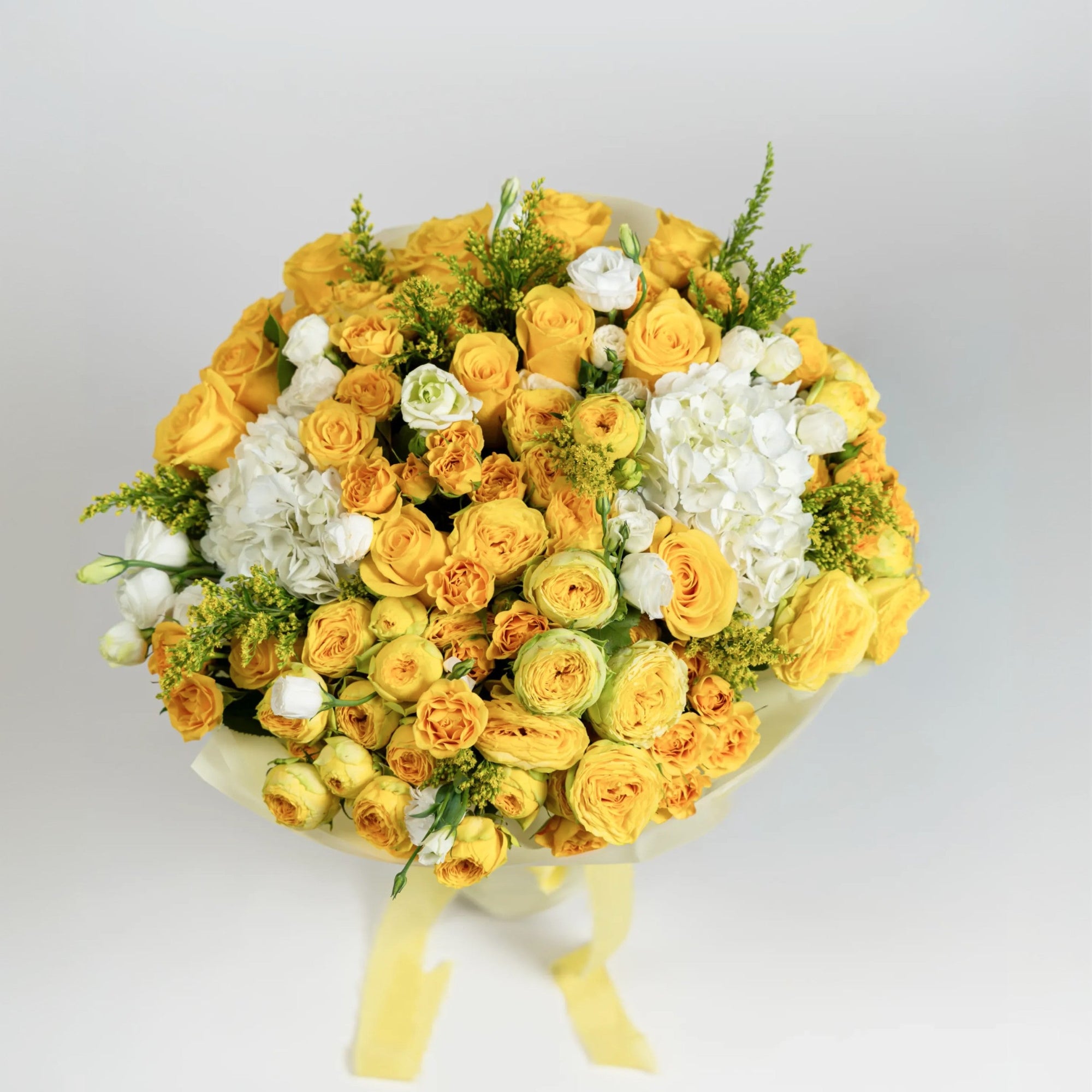 Top view of The Soleil Poème with yellow roses, ranunculus, white hydrangeas and lisianthus