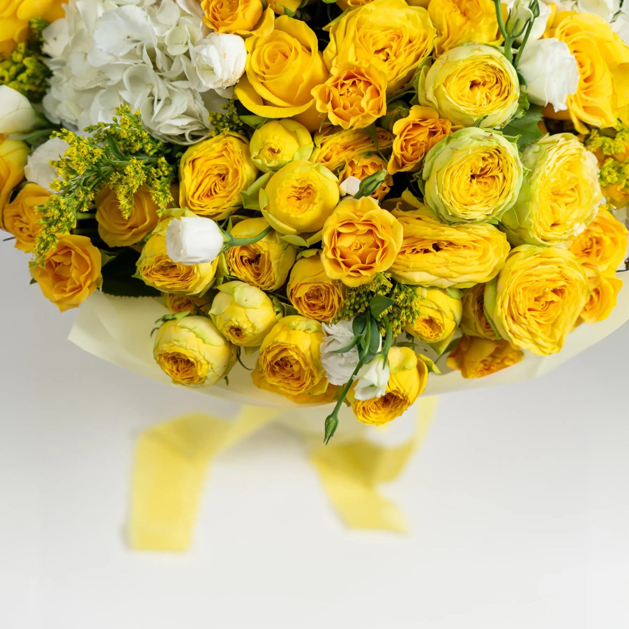 Detailed view of yellow ranunculus and yellow spray roses in a luxury flower bouquet